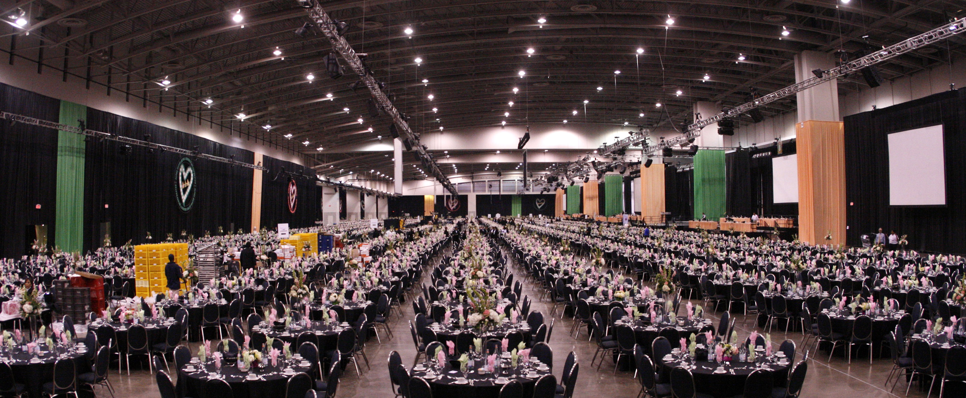 Huge hall filled with round banquet tables set for a seated dinner