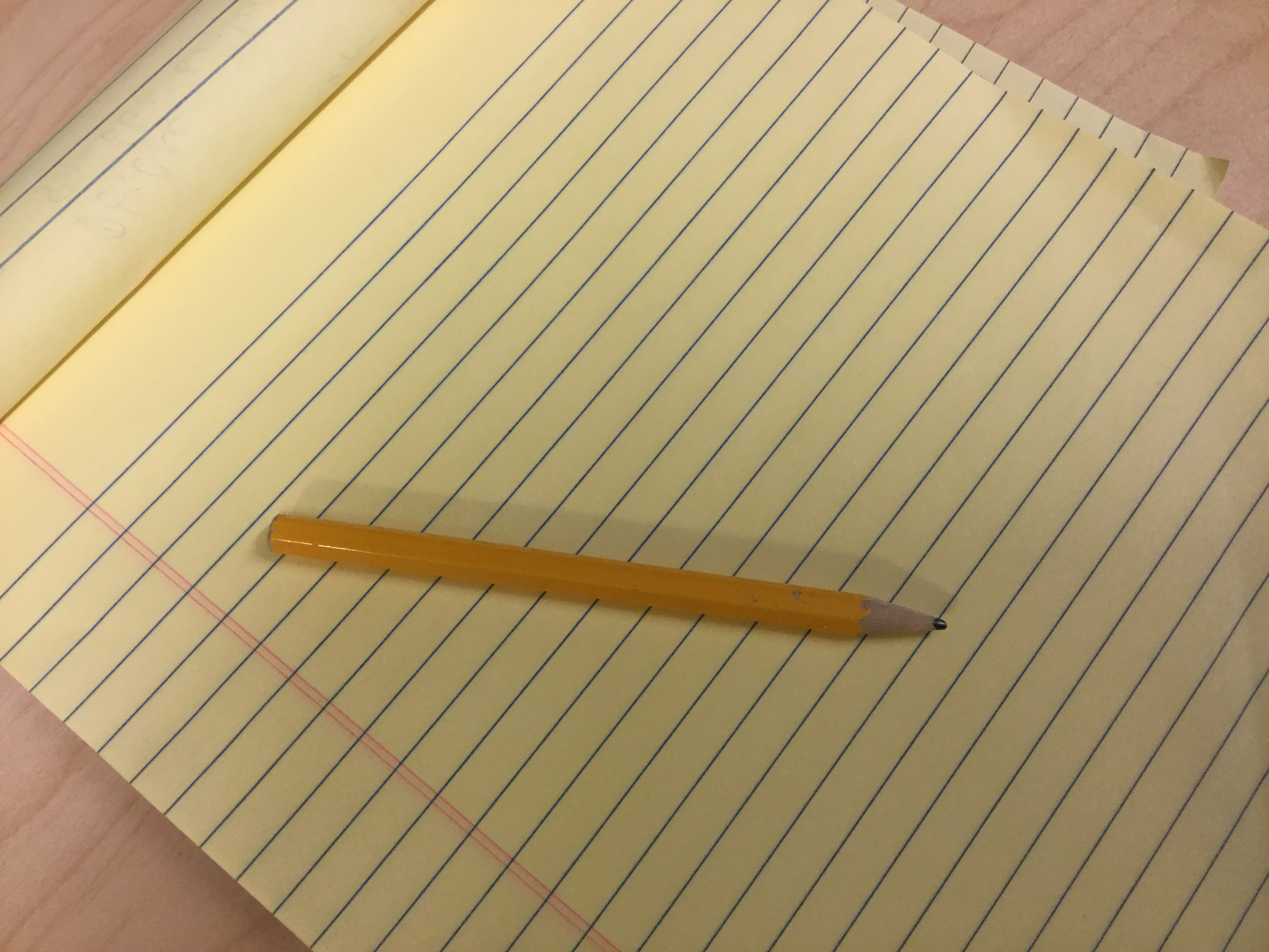 Yellow lined notepad with a pencil, ready for a pen-and-paper game